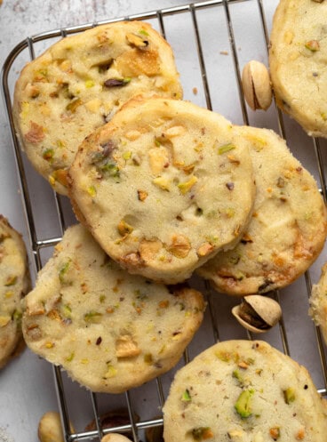 Overhead view of Pistachio Shortbread cookies piled up on a wire rack.