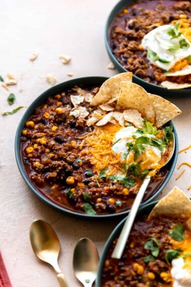 Bowl of taco soup served with cheese, sour cream and tortilla chips.