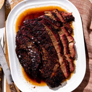 Platter of smoked chuck roast sliced and served with juices.