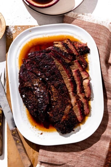 Platter of smoked chuck roast sliced and served with juices.