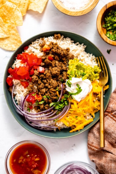 Taco bowl served over rice topped with sour cream.