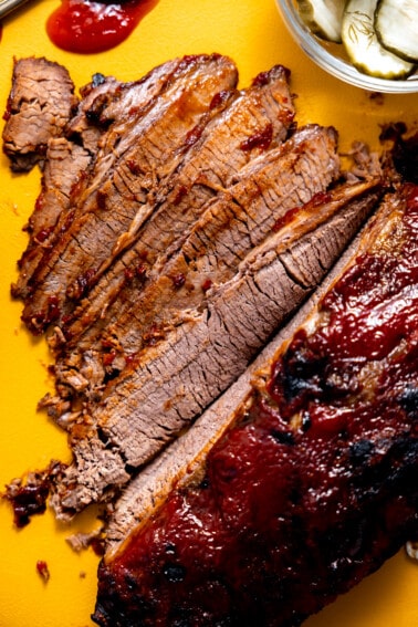 Sliced beef brisket with bbq sauce.