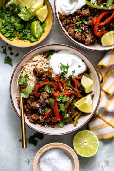 Rice bowl with ground beef fajita meat and bell peppers and onion.