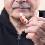 Why should you clean your dentures?