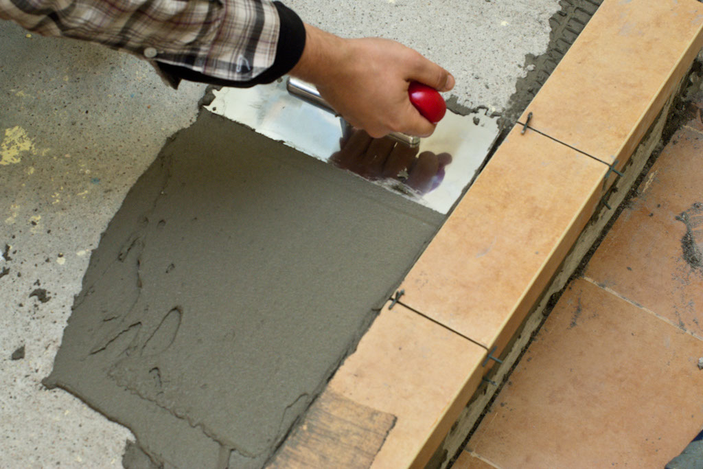 Spreading tile adhesive with trowel