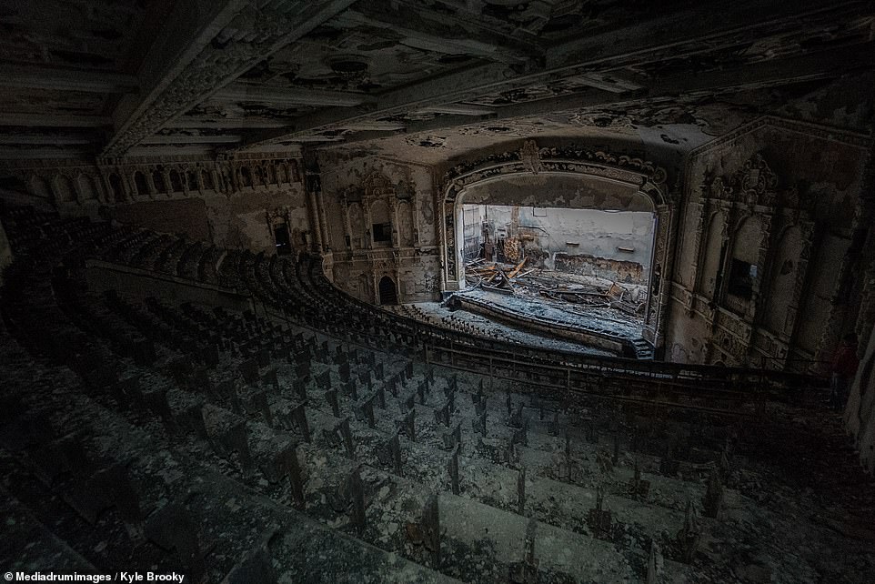 The seats of Cooley High School's derelict auditorium have been mysteriously removed. The decay stands in stark contrast to the ornate molding that decorates the ceiling and stage 