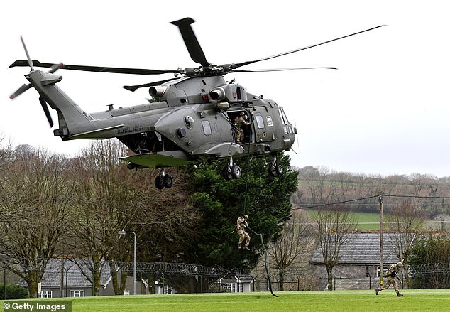 Royal Marines disembarked from a Merlin helicopter (seen) and simulating the rescue of an F35 pilot from the new HMS Queen Elizabeth Aircraft Carrier