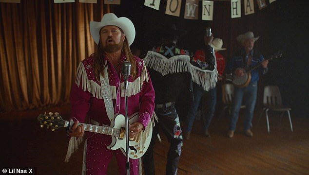 All done up: Billy Ray wears purple cowboy suit with white tassels hanging from it along with a white cowboy hat