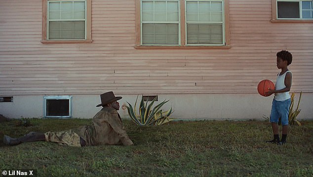 Well hello there: Lil Nas X pops up in modern day America in a family's yard with a stunned little boy standing there flabbergasted