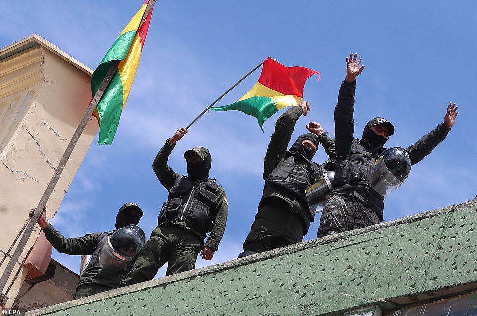 Policemen demonstrate with Bolivian flags after retreating to a unit near Murillo Square, where the headquarters of the Bolivian Government and Legislative are located in La Paz