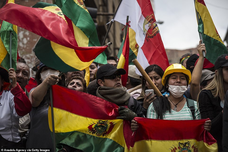 Oppositions protesters demonstrate with their country's flag in front of a police station on Saturday