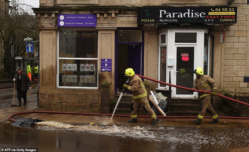 Members of the fire brigade help with clean up efforts in Hebden Bridge, West Yorkshire, after the worst rain since 2015 floods hit over the weekend