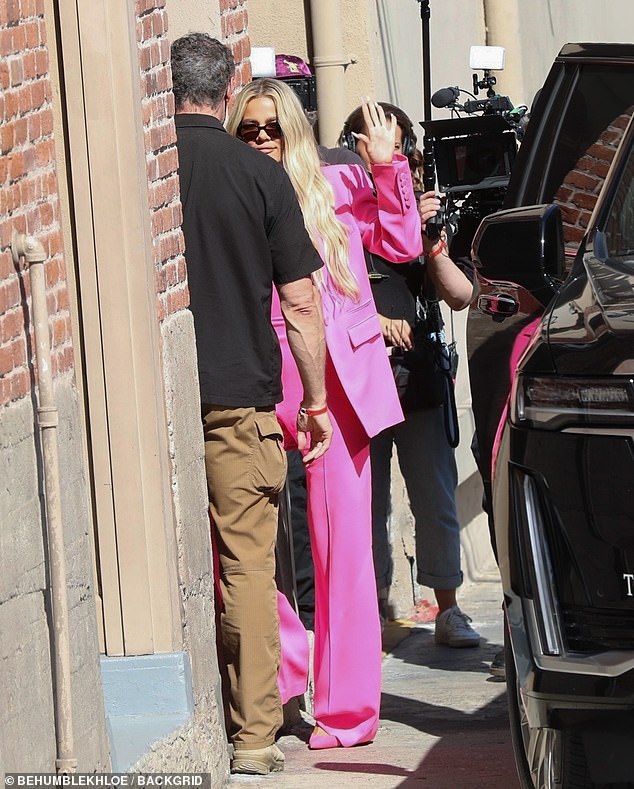 Pretty in pink: Khloé was spotted stepping out of a large black Rolls-Royce in an oversize pink blazer with thick padded shoulders