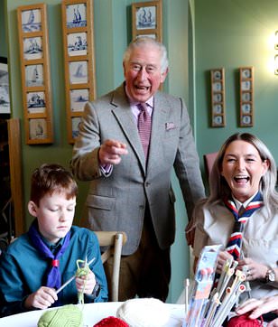 King Charles beams as he is presented with a special hand-knitted cake to mark 10 years of