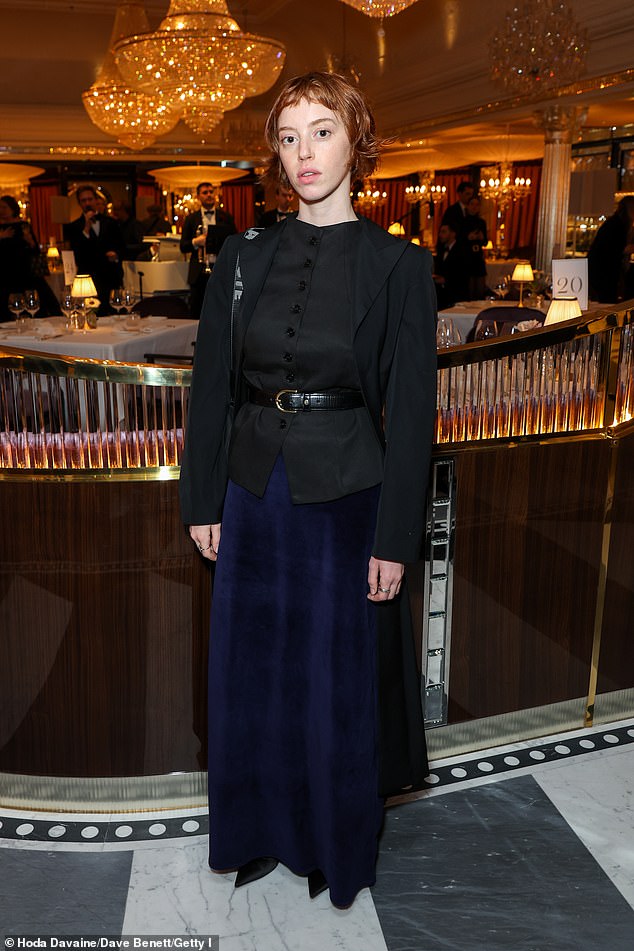 Lily Newmark teamed a black button-up waistcoat with a deep blue satin maxi skirt, styling it with a black belt and a coordinating cropped jacket