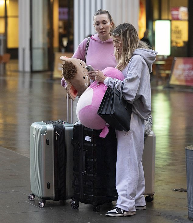 The huge, soft toys were clutched by both women as they looked at a phone while standing outside the building.