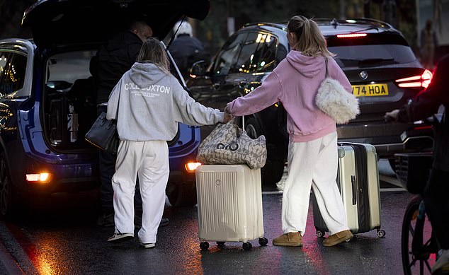 The pair wheeled the suitcases and bags across the road to the waiting car