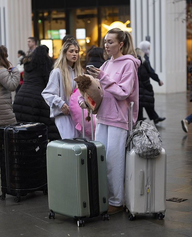 The pair could be seen surrounded by bags as they waited on the London street