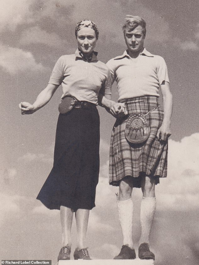 The Duke and Duchess of Windsor strike a bizarre, awkward pose as they hold each other's hands, summer 1937