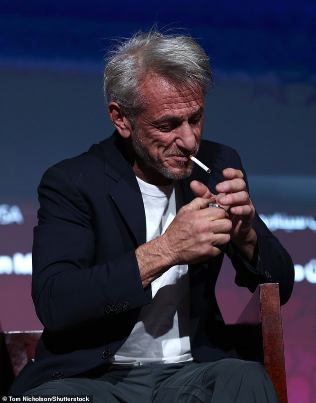 The film director could be seen quickly lighting up a cigarette on stage