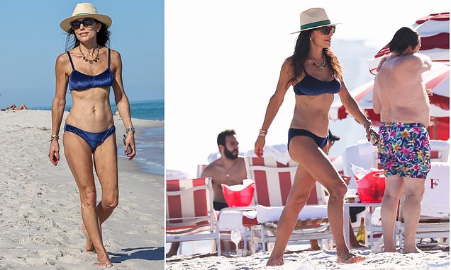 Bethenny Frankel shows off her washboard abs in a blue bikini while taking a stroll on the