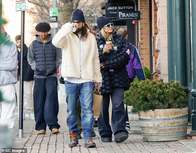 The guitarist added a pair of heavy duty snow boots to his outfit and and was later spotted with a black beanie on