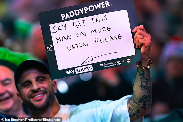 Walker was seen holding a sign in the crowd as he took in the action at Alexandra Palace