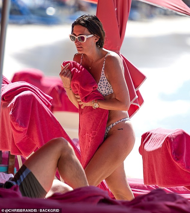 The inseparable Christian couple relaxed in the shaded, sun lounger area of the luxurious resort after their swim