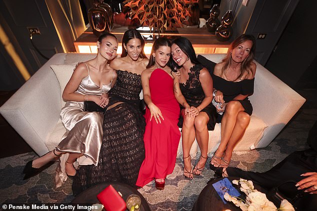 Maren Morris sizzled in a scarlet dress as she lounged on a sofa at the after party with songwriter Ali Tamposi (second to left) and singer Delacey (second to right)