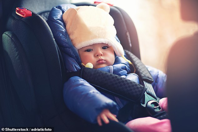 While puffy clothing like big coats, snowsuits, and hoodies may be cosy and comfortable they could pose a hazard to a child wearing them in a car seat. Stock image