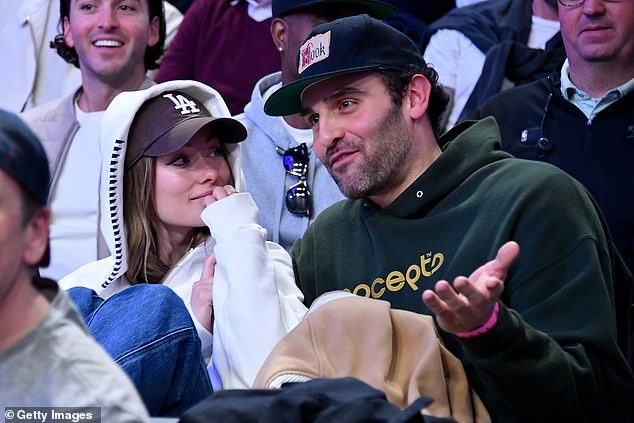 Olivia Wilde cuddles up to actor Dane Diliegro as she is spotted gazing at him during a basketball game as they spark romance rumours two years after her split from ex Harry Styles