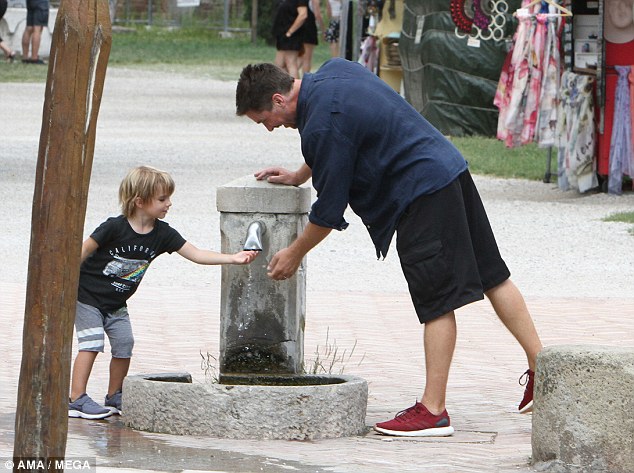 Cool down: Christian and his son took time to cool down as they used a nearby water fountain 