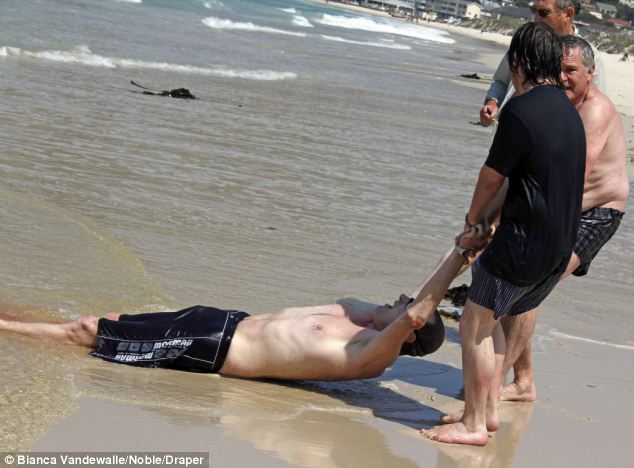 Alive - but only just: Mr Cohen leaves a trail of blood as anxious rescuers pull him from the sea