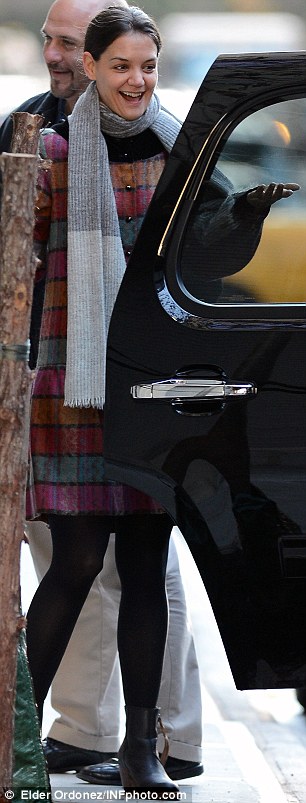 Wrapped up: Katie wore a multi-colour coat and grey scarf to keep warm