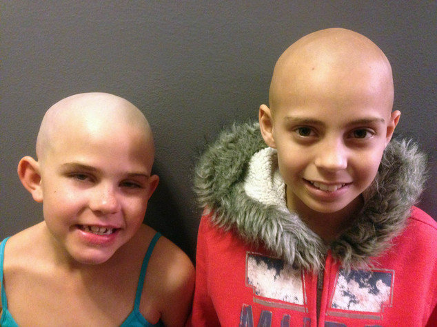 Source of support: Kamryn Renfro, nine, left, had her head shaved to support Delaney Clements, 11, who lost her hair to cancer treatment