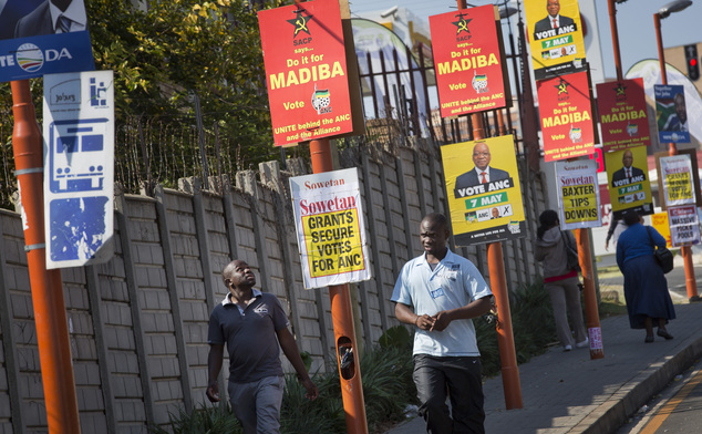 Pedestrians walk past electoral campaign posters on a street in Johannesburg, South Africa Friday, May 2, 2014. South African political parties hold final ca...