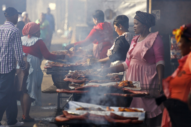 Woman cook meat to be sold direct to the public at a local market in Nyanga township on the outskirts of the city of Cape Town, South Africa, Thursday, May 1...