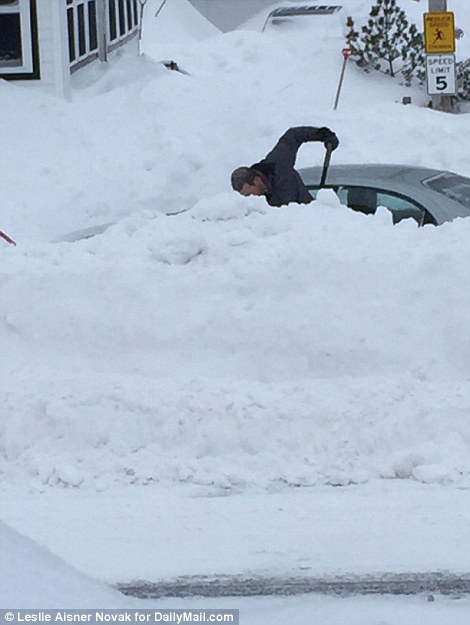 Engulfed: A man works to free his car from the snow drifts that have fallen around New England after more than 71 inches of snow over the past 17 days