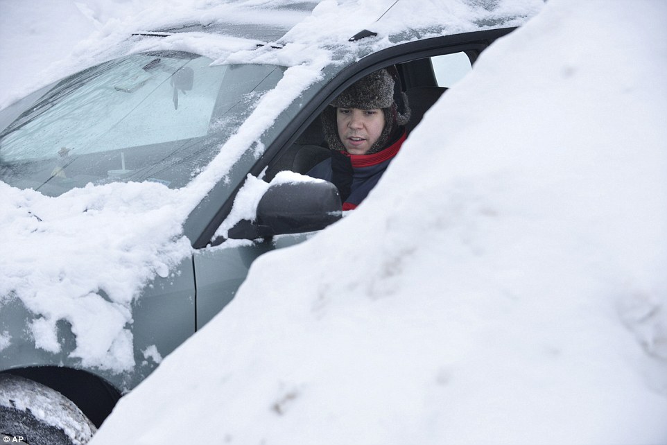 Used to warmer climes: Will Chapman, of Oakland, California, works to free his car from between snow piles near the house he was visiting in Somerville after the snowstorm left New England covered in another two feet of snow