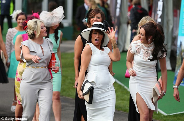 A female racegoers poses for a picture as she arrives for Ladies' Day at Aintree Racecourse last year