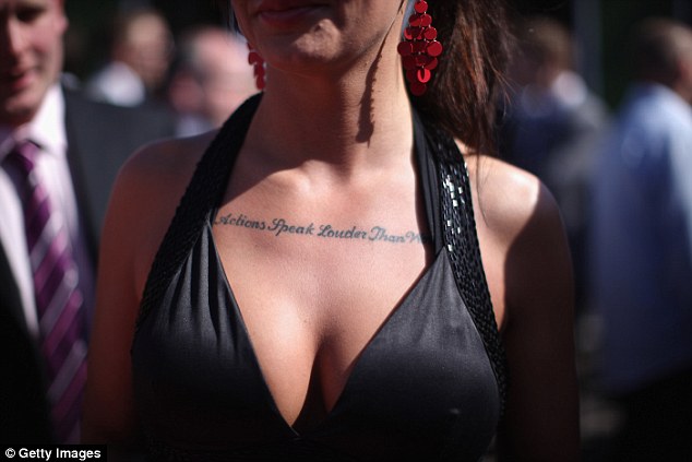 A woman shows off the tattoo on her chest during Ladies' Day at the Aintree Grand National meeting in 2011