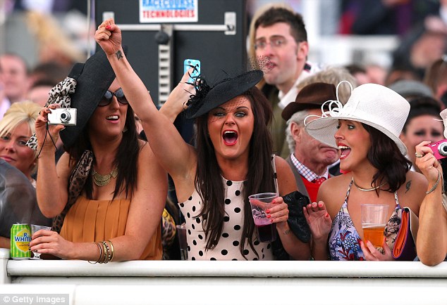 Racegoers cheer on their horses during The Tangle Teezer Top Novices' Hurdle Race on Ladies' Day in 2012