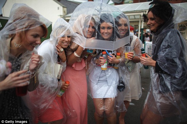 Racegoers brave the rain as they refuse to let it spoil the occasion at Ladies' Day in April 2013 