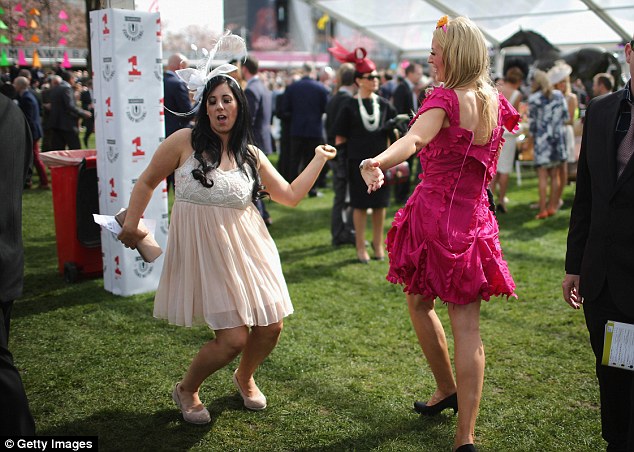 Racegoers dance and enjoy the party atmosphere of Ladies Day at the Grand National Festival meeting