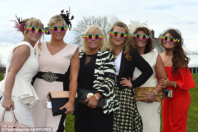 Racegoers pose in novelty glasses at the Crabbie's Grand National Festival 2014