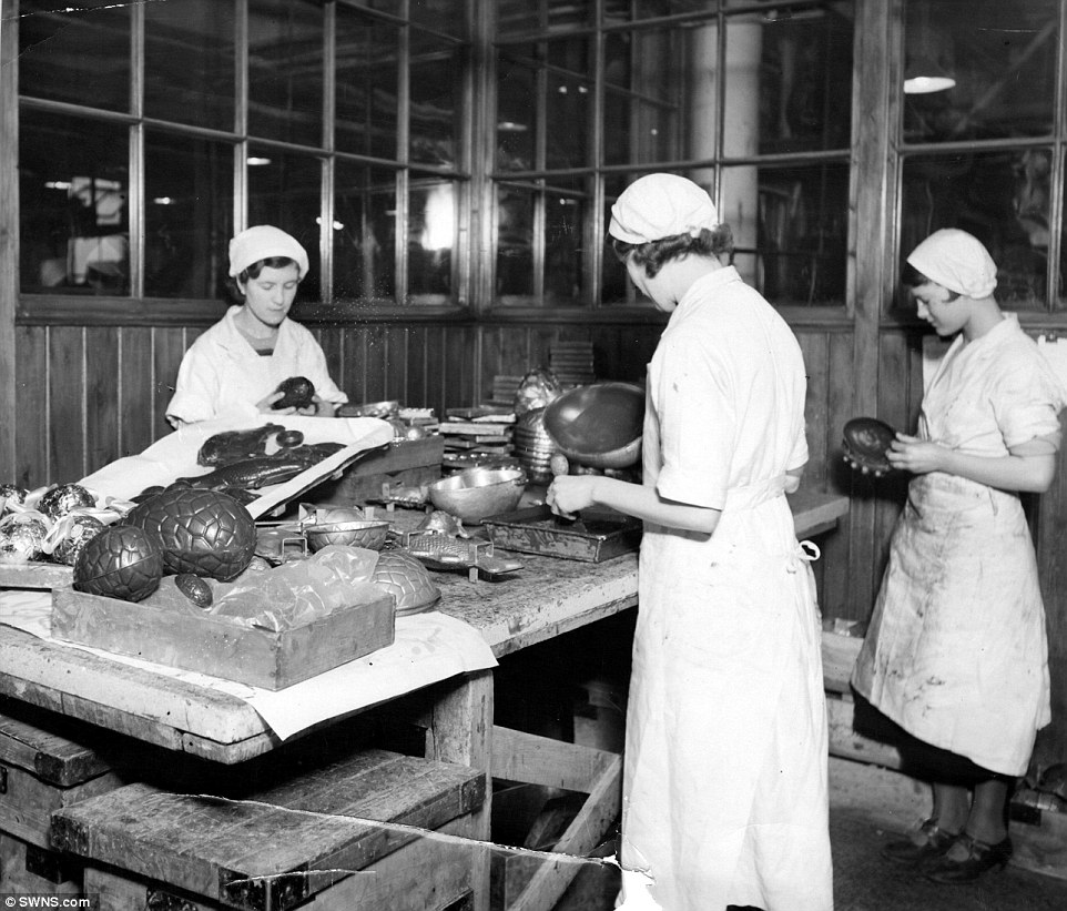 Female Harrods employees in the late 1920s, dressed in white aprons and hats, remove the chocolate Easter eggs from their moulds