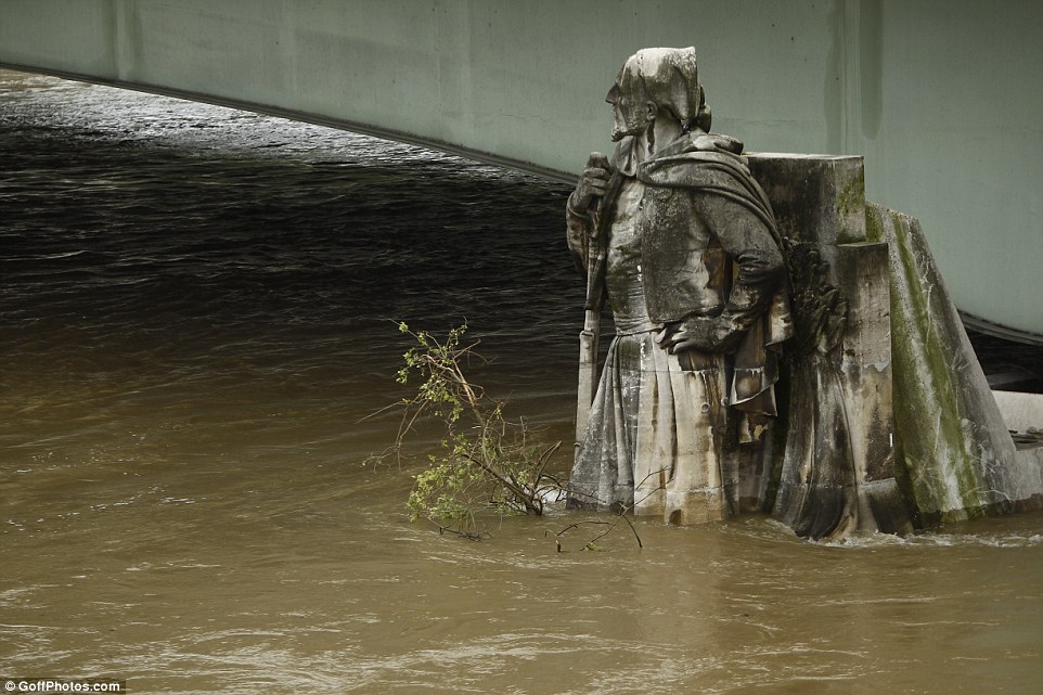 The statue of Zouave under the Pont d'Alma was still partially submerged under the rushing flood waters in the Seine on Saturday