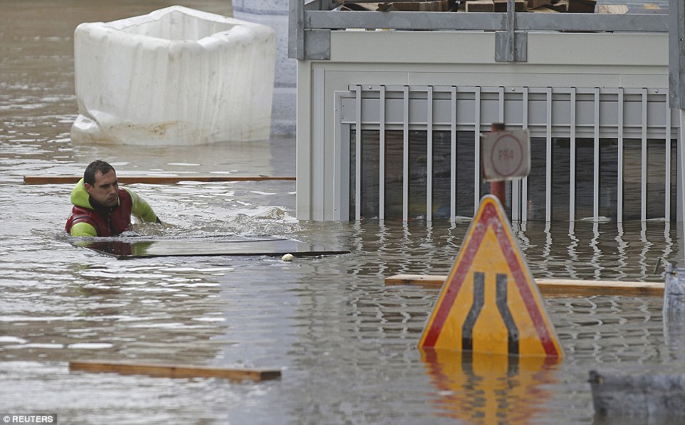 A diver from Paris fire brigade removes garbage on the flooded banks of the river Seine on Saturday