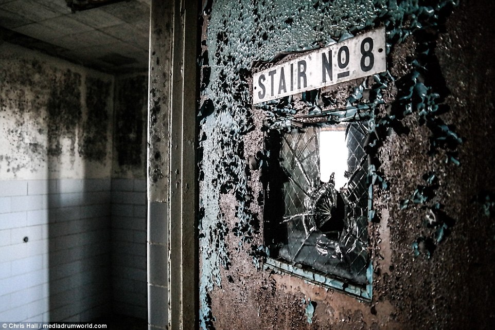 This eerie photograph shows a shattered glass window in a door leading to a stairwell in St Elizabeth's Hospital