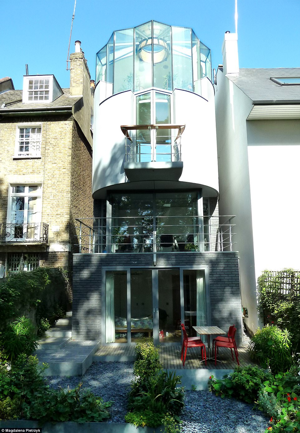 Nautical feel: The four-storey property which features a solid circular front that faces the street, and a upturned glass hull perched on top, pictured. It has been ridiculed by neighbours throughout the 12-year build but left impressed the judges